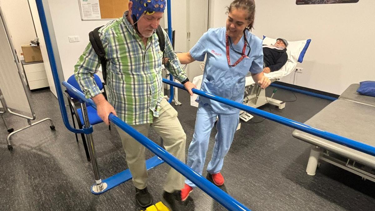 Uno de los pacientes de la unidad realizando ejercicios físicos guiado por una fisioterapeuta del Hospital del Vinalopó en el nuevo gimnasio rehabilitador de daños cerebrales