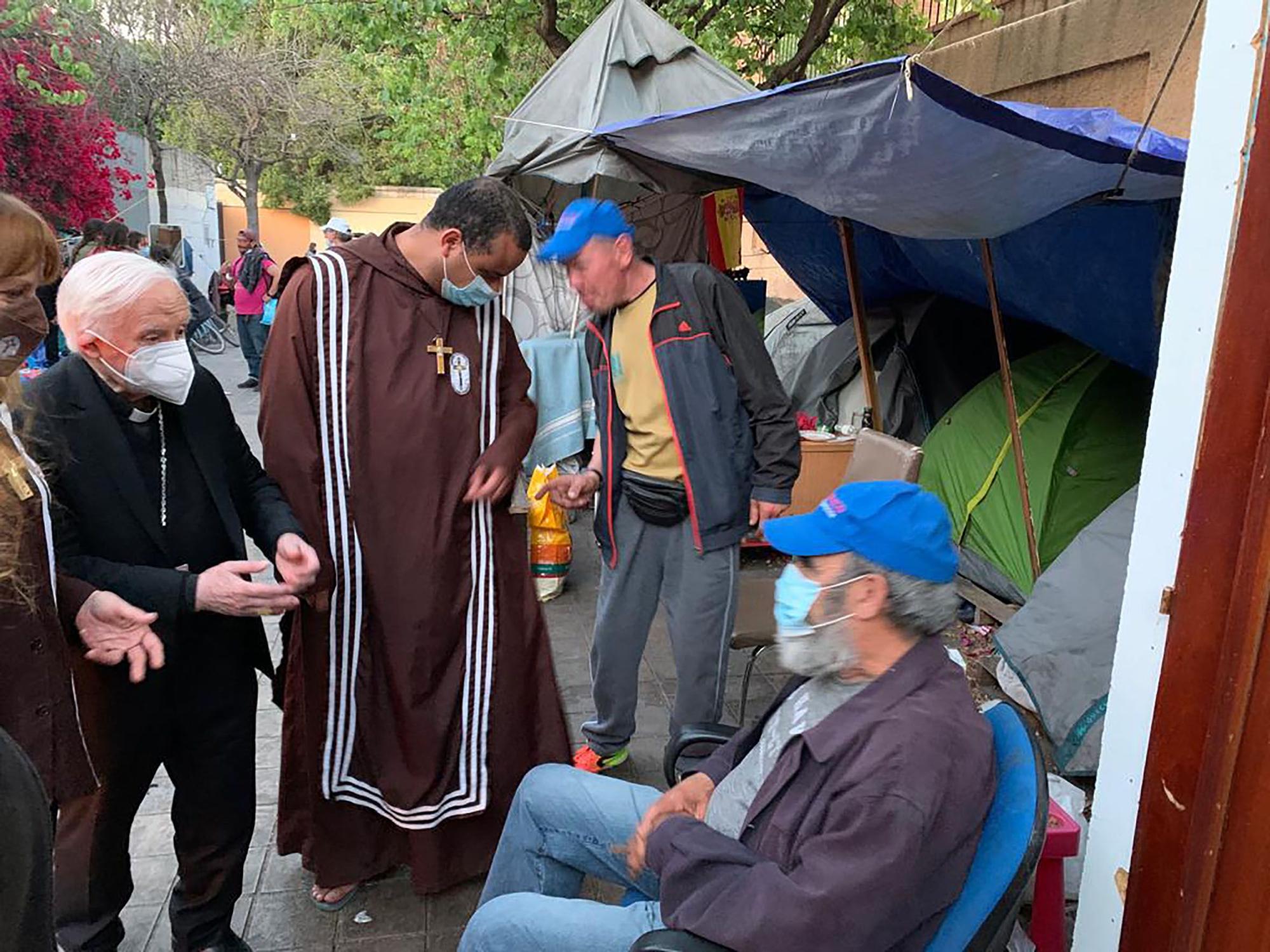 El cardenal Cañizares visita el campamento de la calle Gaspar Bono