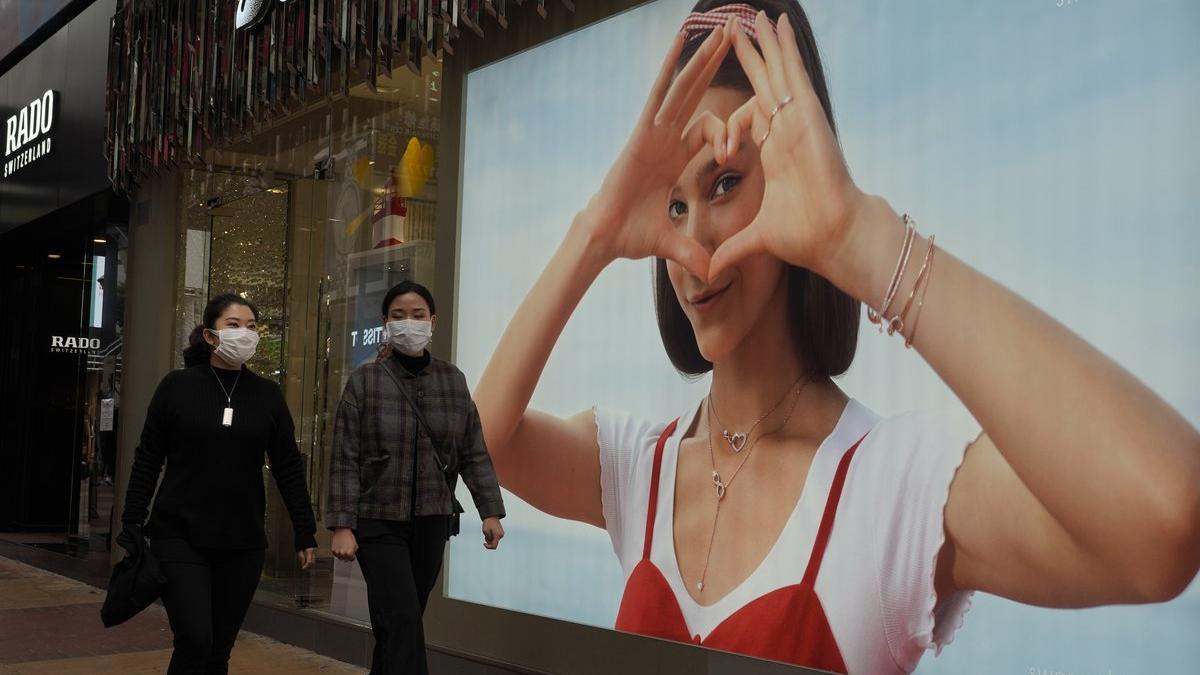 Dos mujeres protegidas con mascarillas pasean por Hong Kong.