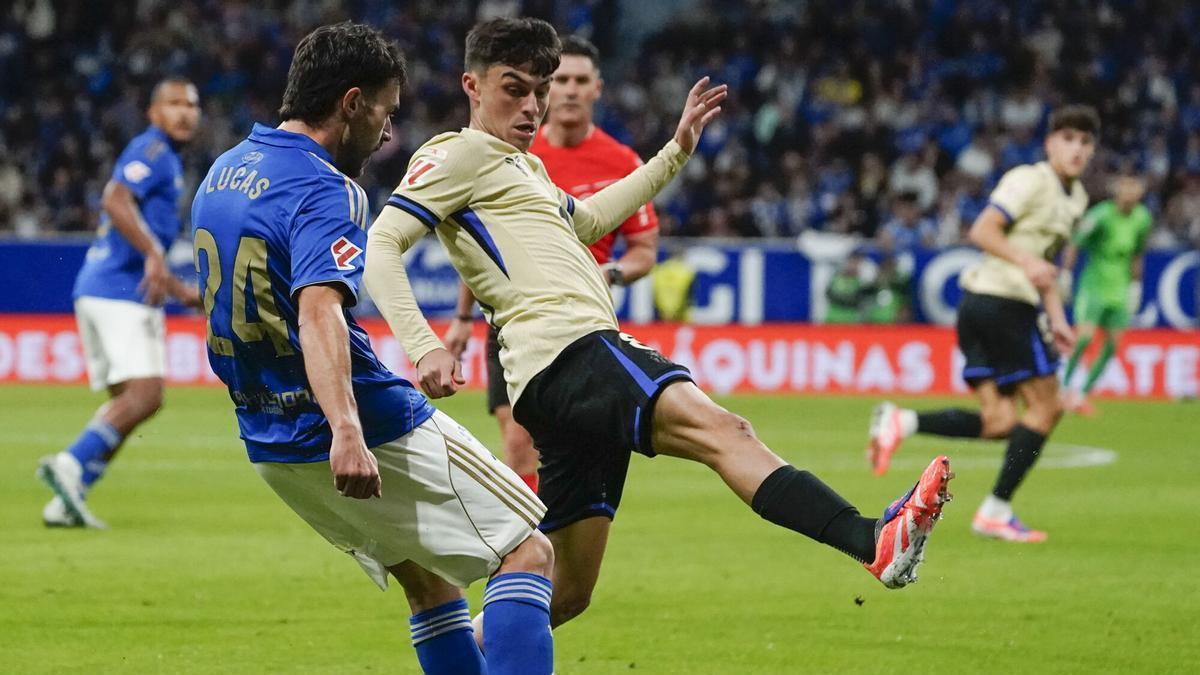 El defensa del Oviedo lucas Ahijado (i) trata de jugar un balón ante Pedri, del Barcelona, durante el partido de la sexta jornada de LaLiga EA Sports que Real Oviedo y FC Barcelona disputan en el estadio Carlos Tartiere. EFE/Paco Paredes. (Oviedo) (Barcelona)