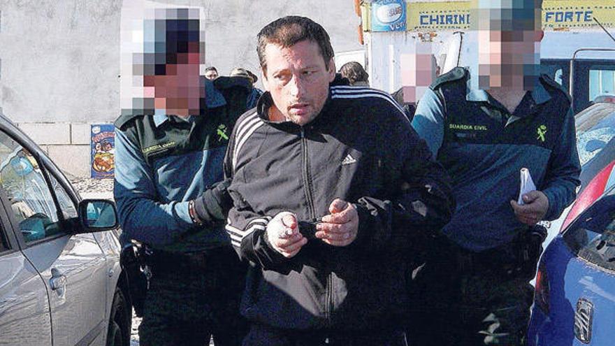 El detenido, con la mano derecha vendada, sale ayer del quiosco donde se produjo el crimen, escoltado por la Guardia Civil.  // Gonzalo Núñez