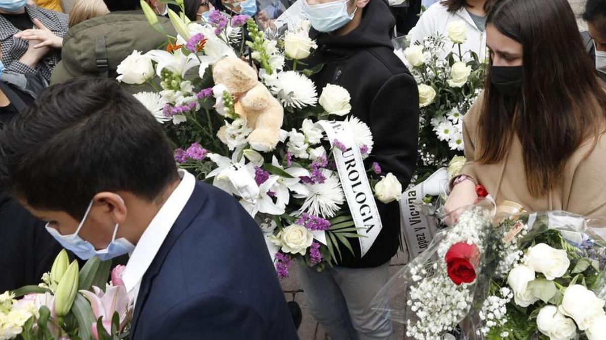 Compañeros y amigos de Erika Yunga salen de su funeral en la capilla de la residencia María Inmaculada, el 7 de abril de 2022, cargados de ramos y coronas de flores.