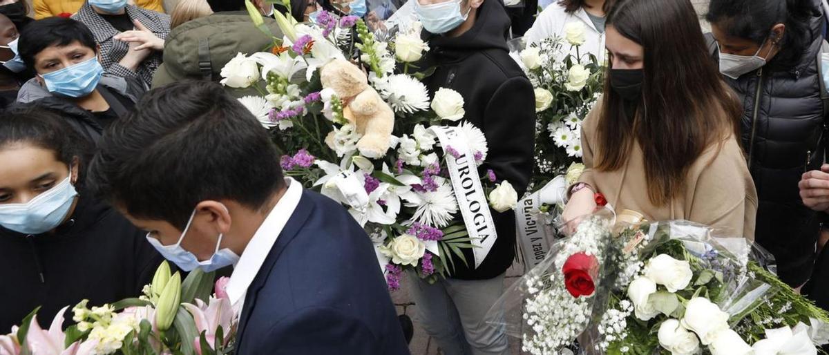 Compañeros y amigos de Erika Yunga salen de su funeral en la capilla de la residencia María Inmaculada, el 7 de abril de 2022, cargados de ramos y coronas de flores.