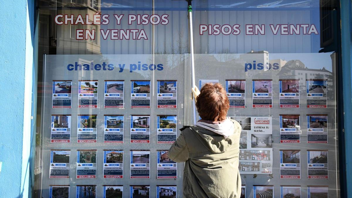 UNA PERSONA CONSULTA LAS OFERTAS EN UN ESCAPARATE DE UNA INMOBILIARIA EN LA CIUDAD DE A CORUÑA / SECTOR INMOBILIARIO. VENTA. ALQUILER. PISOS. VIVIENDAS. PROPIEDADES