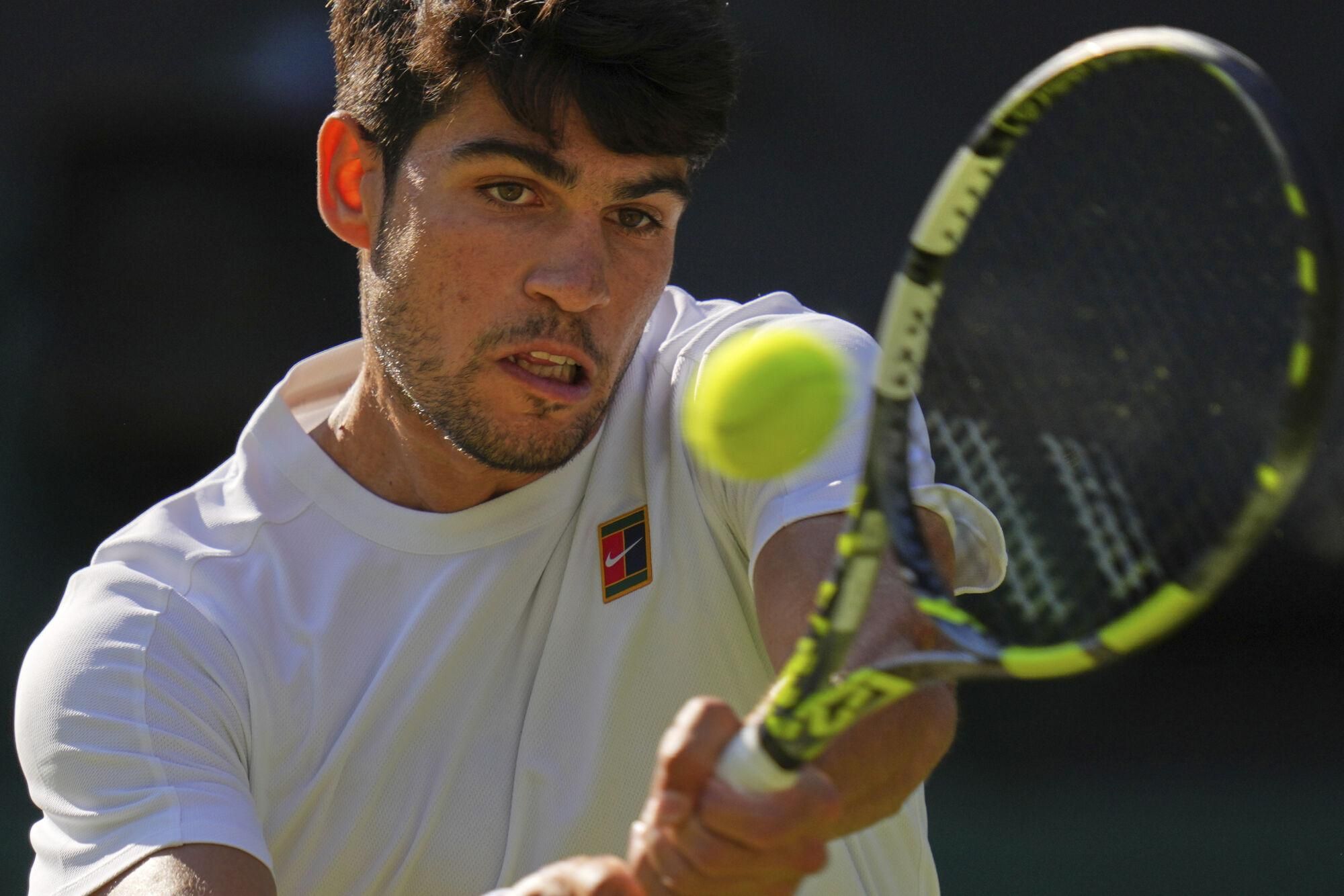 Spain's Carlos Alcaraz returns to Britain's Cameron Norrie during a quarterfinal men's singles match at the Wimbledon Tennis Championships in London, Tuesday, July 8, 2025. (AP Photo/Kirsty Wigglesworth)