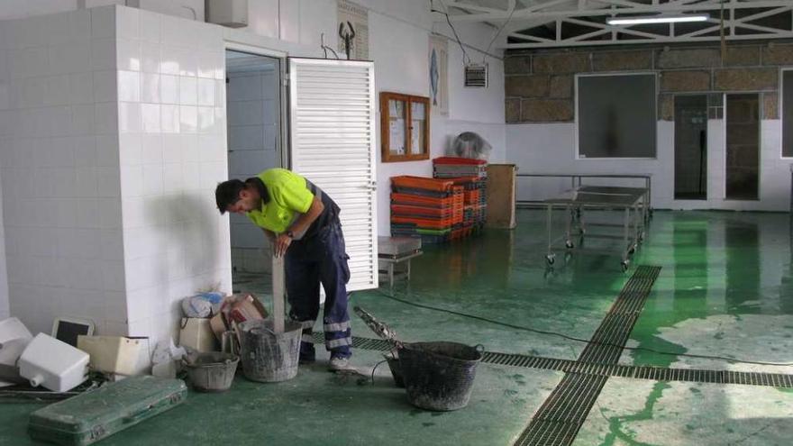 Un operario municipal trabaja en la reforma de la lonja de Panxón.