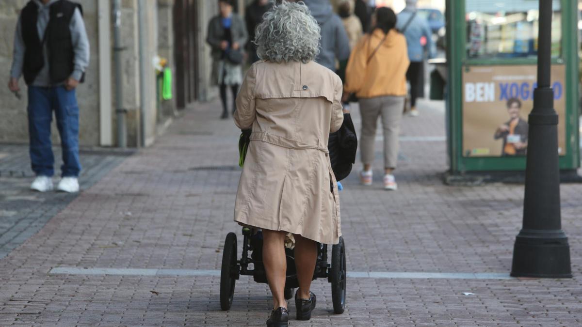 Una mujer empuja a una persona en silla de ruedas