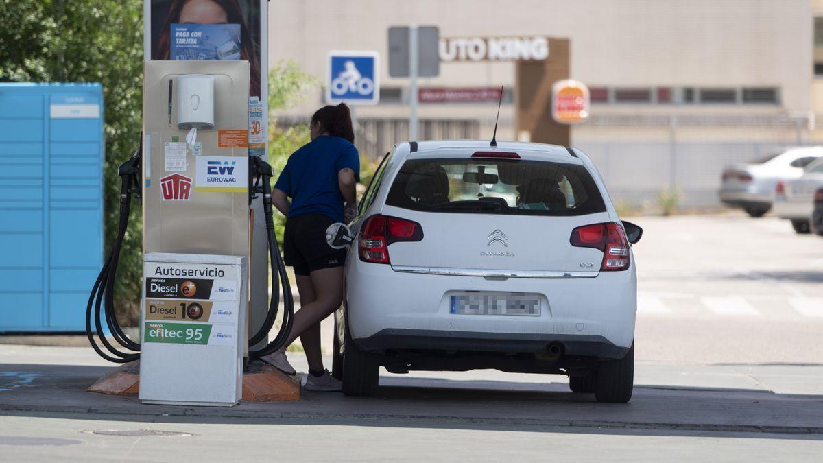 Una mujer pone gasolina en una estación de servicio.