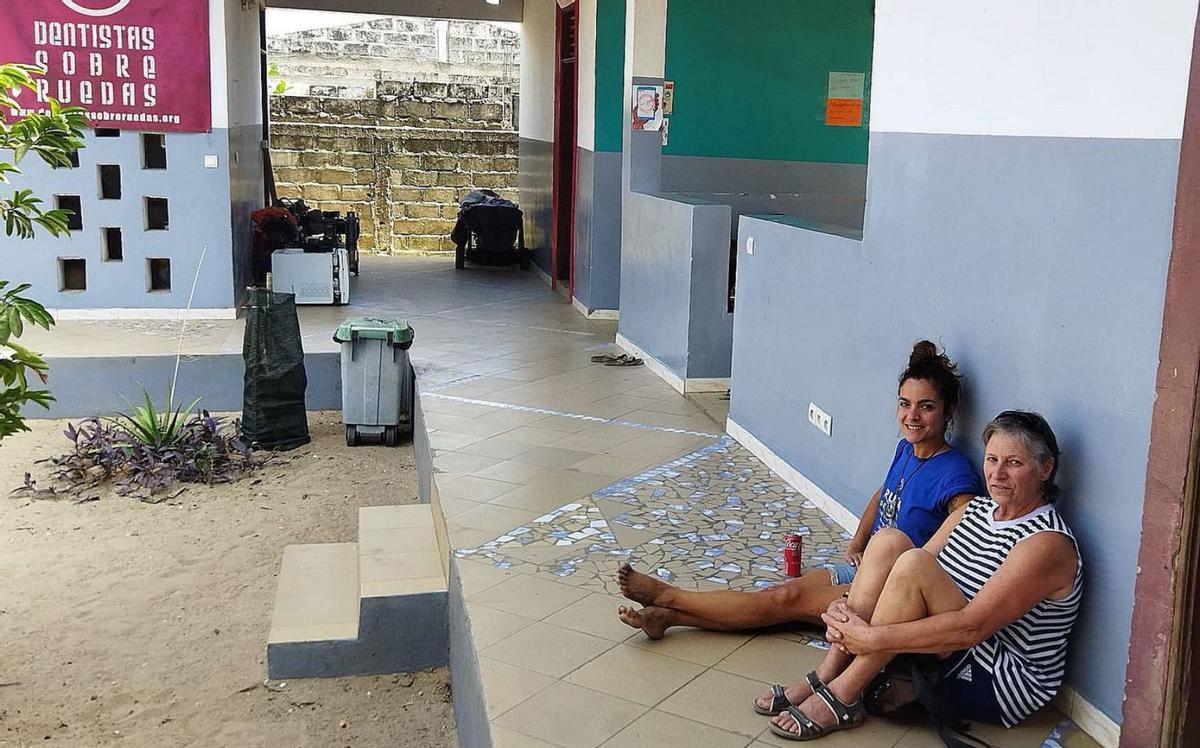 Myriam Portela, con su madre, descansa frente al centro médico local.   | // FDV