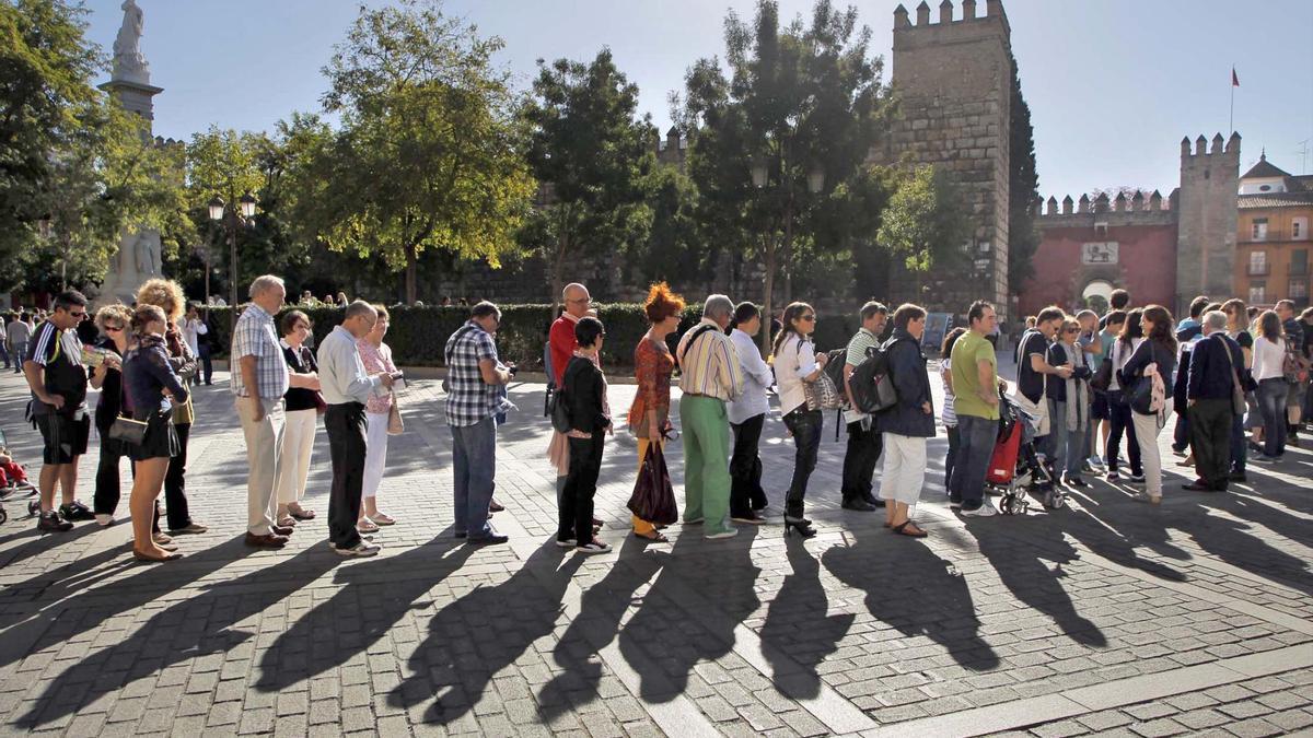 Una kilométrica cola, imagen habitual para cualquier paseante, se organiza en la puerta de acceso al Real Alcázar de Sevilla. / Paco Puentes