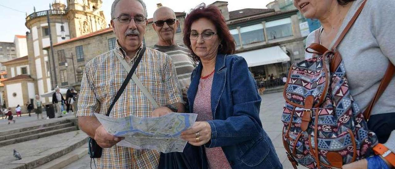 Un grupo de turistas de Mallorca consultando ayer un mapa en la Praza da Ferrería. // Gustavo Santos