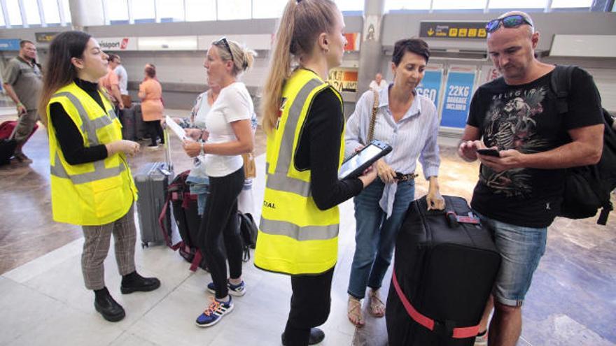 Varios turistas reciben información en el aeropuerto de Tenerife Sur.