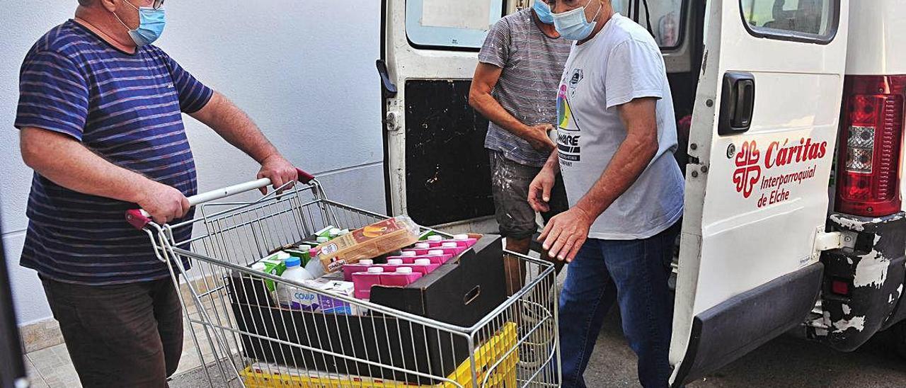 Descarga de comida en la sede principal de Cáritas Elche, ubicada junto al puente del Bimil.lenari. MATÍAS SEGARRA