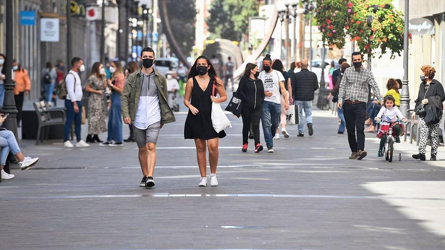 Varia personas con mascarillas en la calle Triana. | | JUAN CASTRO