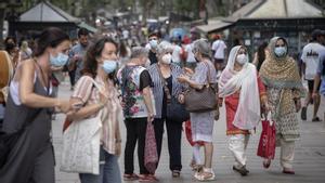 Gente paseando con mascarilla y sin mascarilla en La Rambla de Barcelona.