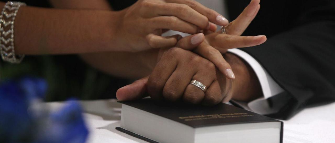 Las manos de dos novios se entrelazan tras ponerse los anillos en la ceremonia de la boda. | O. B.