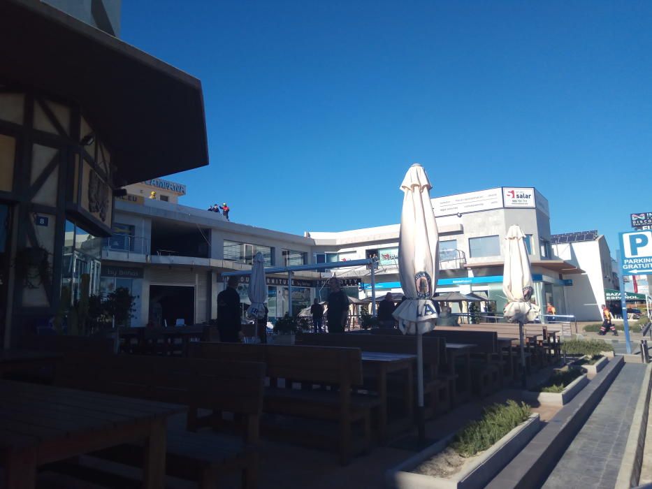 El viento derriba un cartel de grandes dimensiones sobre la terraza de un centro comercial en Orihuela Costa sin causar víctimas