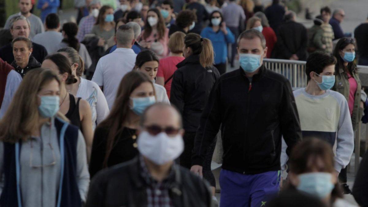 Personas con su mascarilla pasean por la calle.