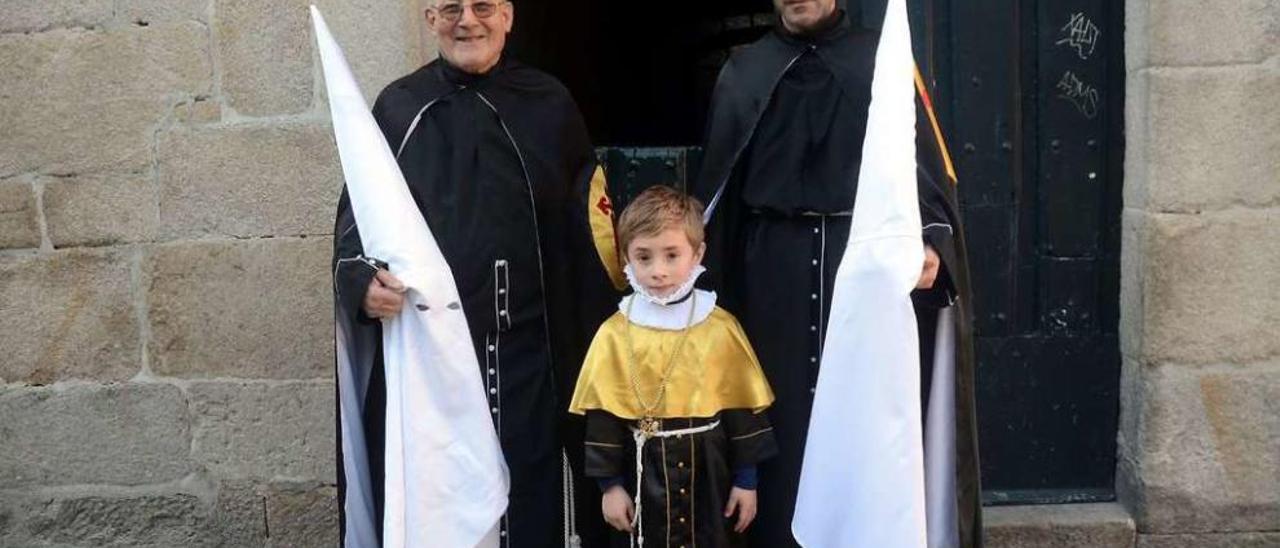 Celestino Peón y Ramón Peón, junto al pequeño Ero Peón, de 5 años, son miembros de la Cofradía del Silencio. // Rafa Vázquez