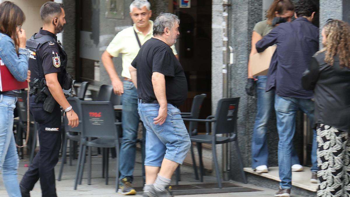 El detenido, acompañado por agentes al inicio del registro de su domicilio en la avenida de Castrelos.