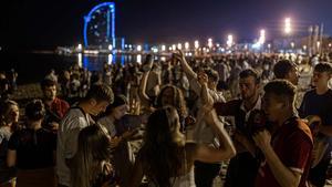 Jóvenes de botellón en la playa de la Barceloneta.