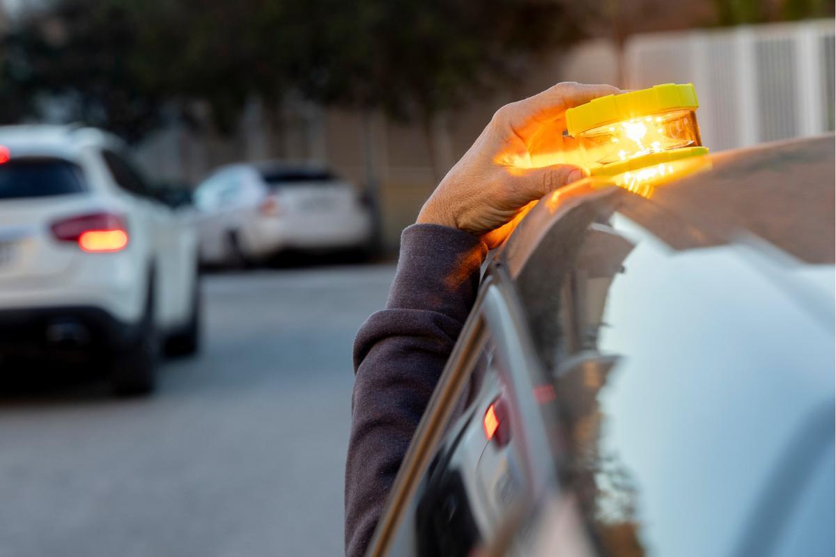 Un conductor colocar la baliza V-16 en el techo de su coche.