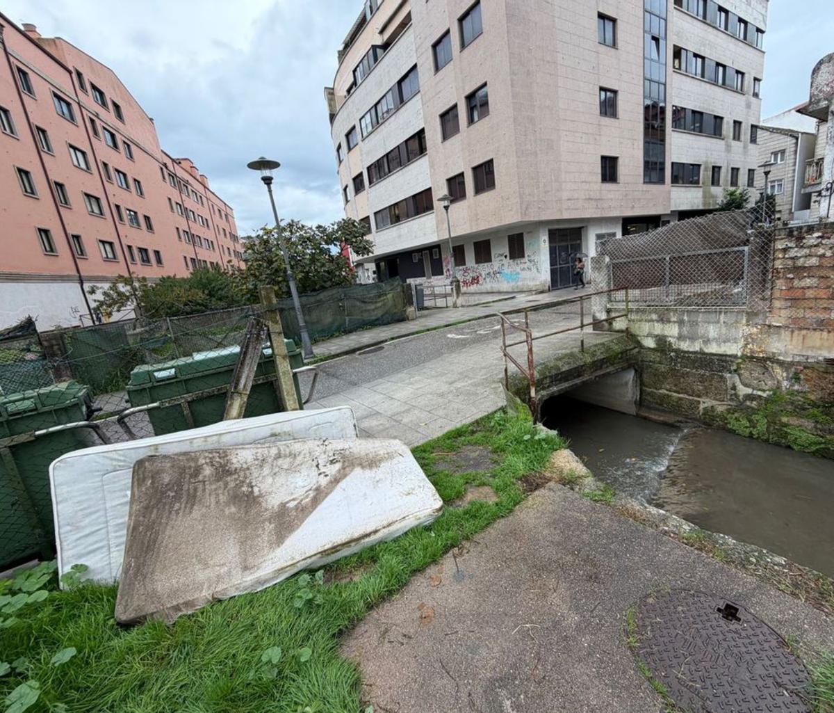 El concejal Antón Iglesias, junto a una alcantarilla en las márgenes del río Bouzós. | FdV