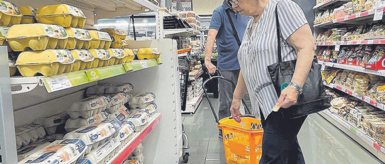 Una dona i un home compren productes en un supermercat en una fotografia d’arxiu. | FERRAN NADEU