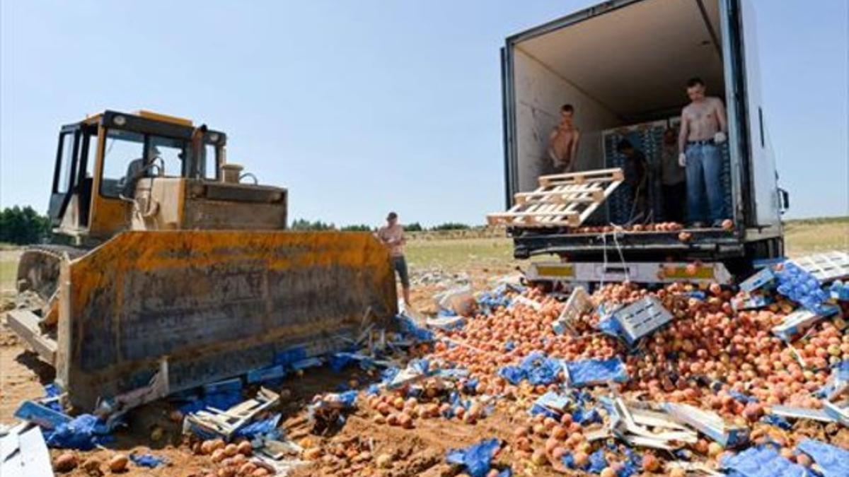 Un bulldózer aplasta melocotones en Rusia, el pasado 7 de agosto.