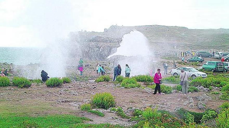 Decenas de turistas y de vehículos, al pie de los bufones de Pría, en una imagen tomada el pasado otoño.