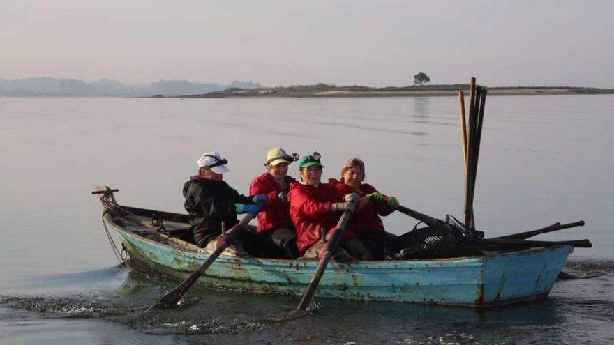 Cuatro mariscadoras de a pie regresan a tierra tras trabajar en una zona intermareal de A Toxa. // Muñiz