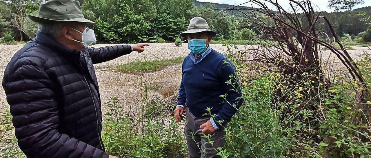 Los kiwicultores Paco Feito y Ángel Cuesta, ayer, delante del islote de regodón que afecta a sus plantaciones en Peñaullán (Pravia).