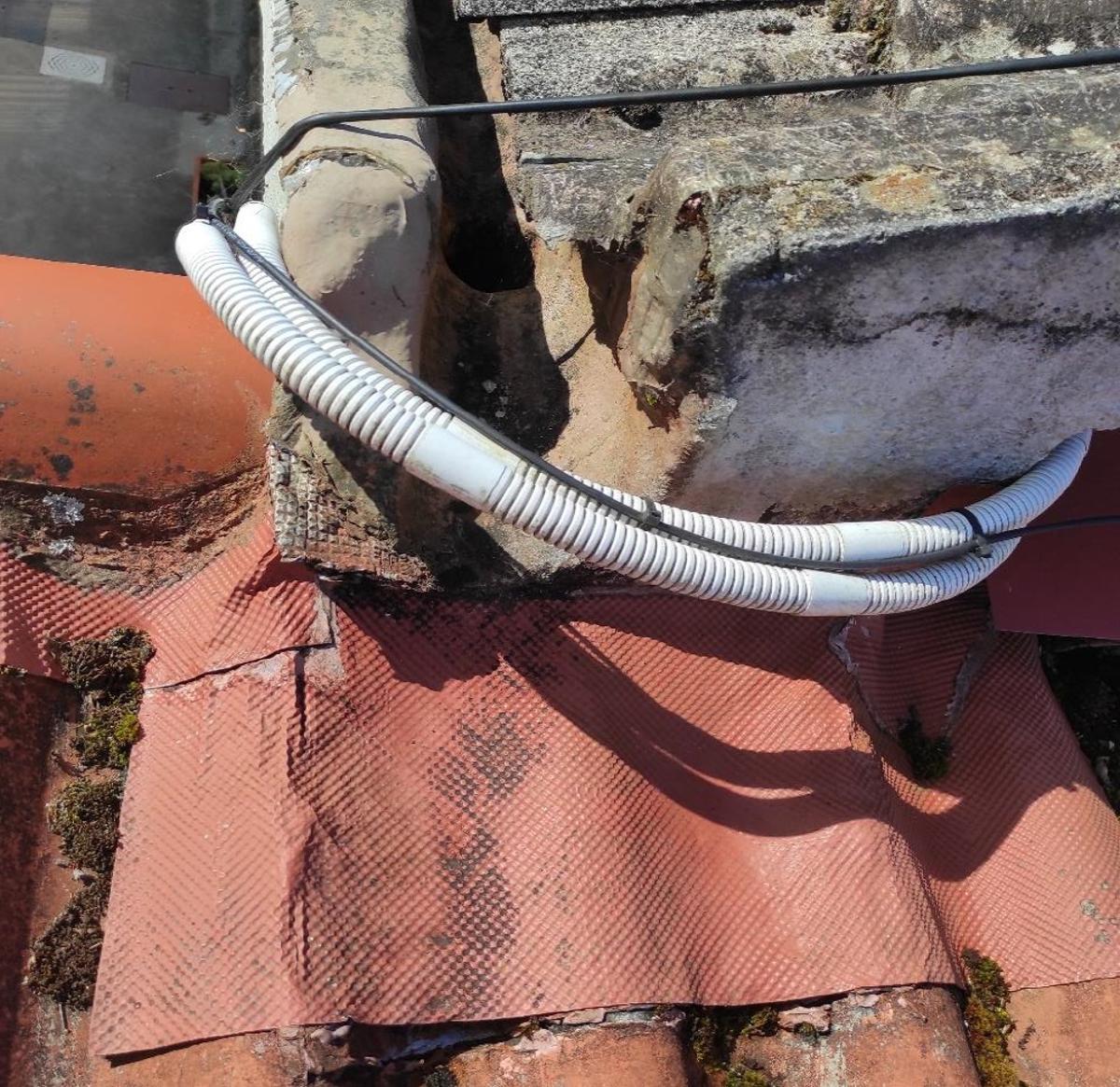 Detalle de canalón en edificio de aulario y paso de cables muy próximo.
