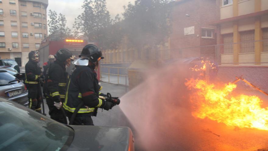 Bomberos sofocan el incendio de un contenedor en una calle de Cartagena; los expertos tienen claro    que todos los sucesos así son provocados y alertan de que detrás de ellos podría haber pirómanos.