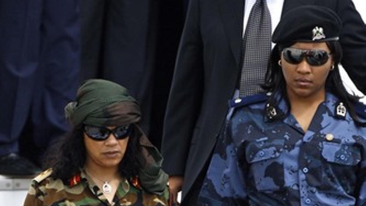Gadafi baja de un avión seguido por guardaespaldas femeninas.