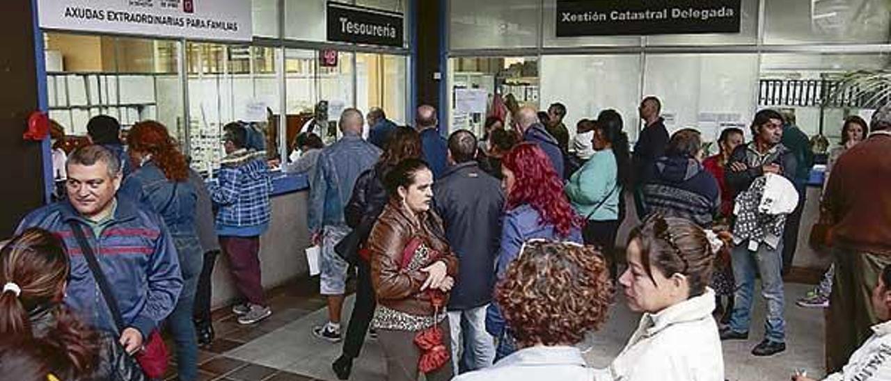 Ciudadanos haciendo trámites en la lonja del Concello.  // FdV