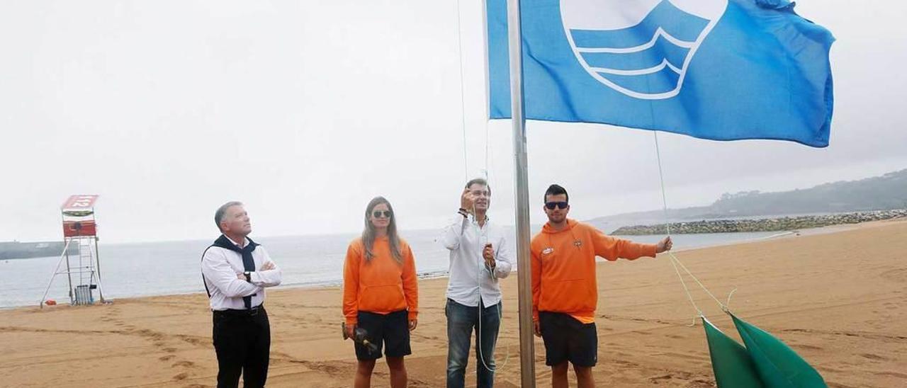 Jorge Suárez iza la bandera azul en la playa de Luanco en julio de 2015.