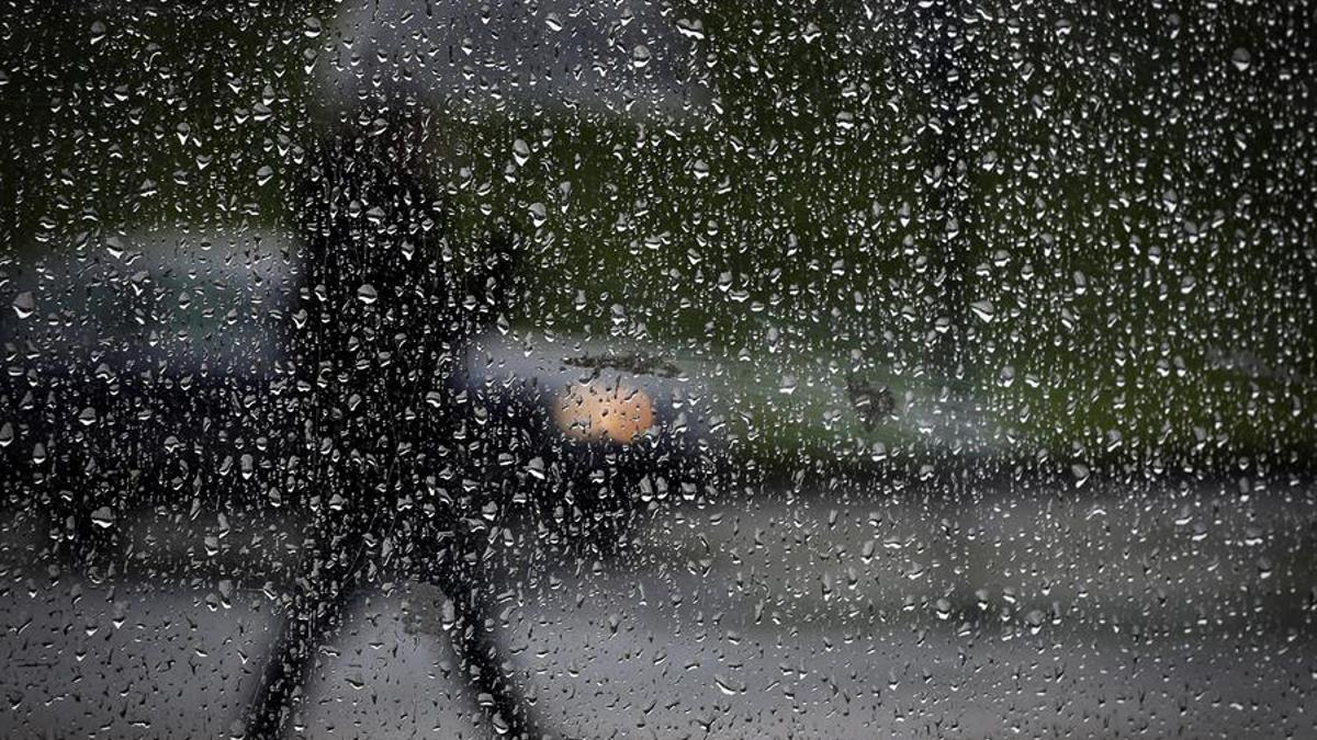 Un hombre camina bajo la lluvia.