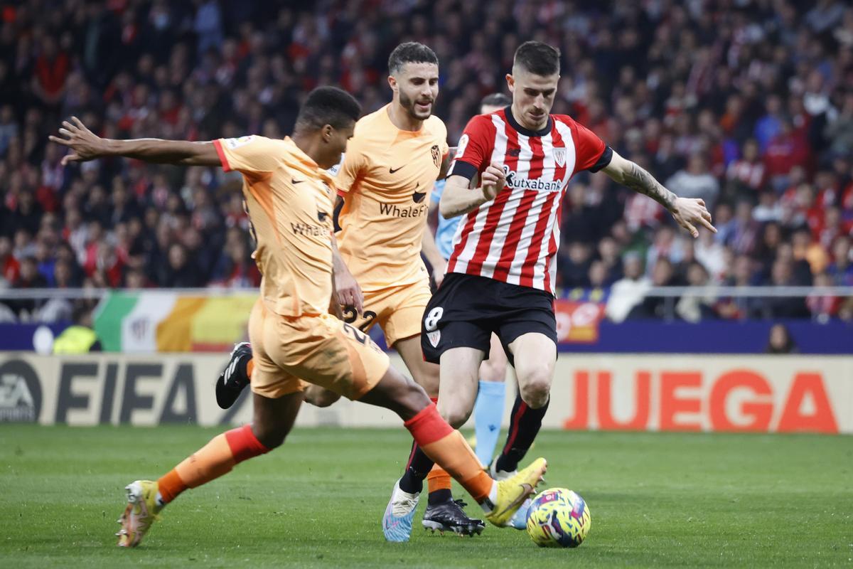 MADRID, 19/02/2023.- El centrocampista del Athletic Club, Oihan Sancet (d), intenta superar al centrocampista mozambiqueño del Atlético de Madrid, Reinildo Mandava, durante el encuentro correspondiente a la jornada 22 que disputan hoy domingo en el estadio Metropolitano, en Madrid. EFE / Juan Carlos Hidalgo.