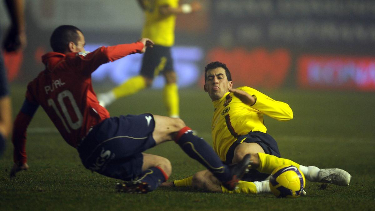 Busquets disputa un balón desde el suelo con el jugador de Osasuna, Puñal, en partido de liga en El Sadar, en enero de 2009.
