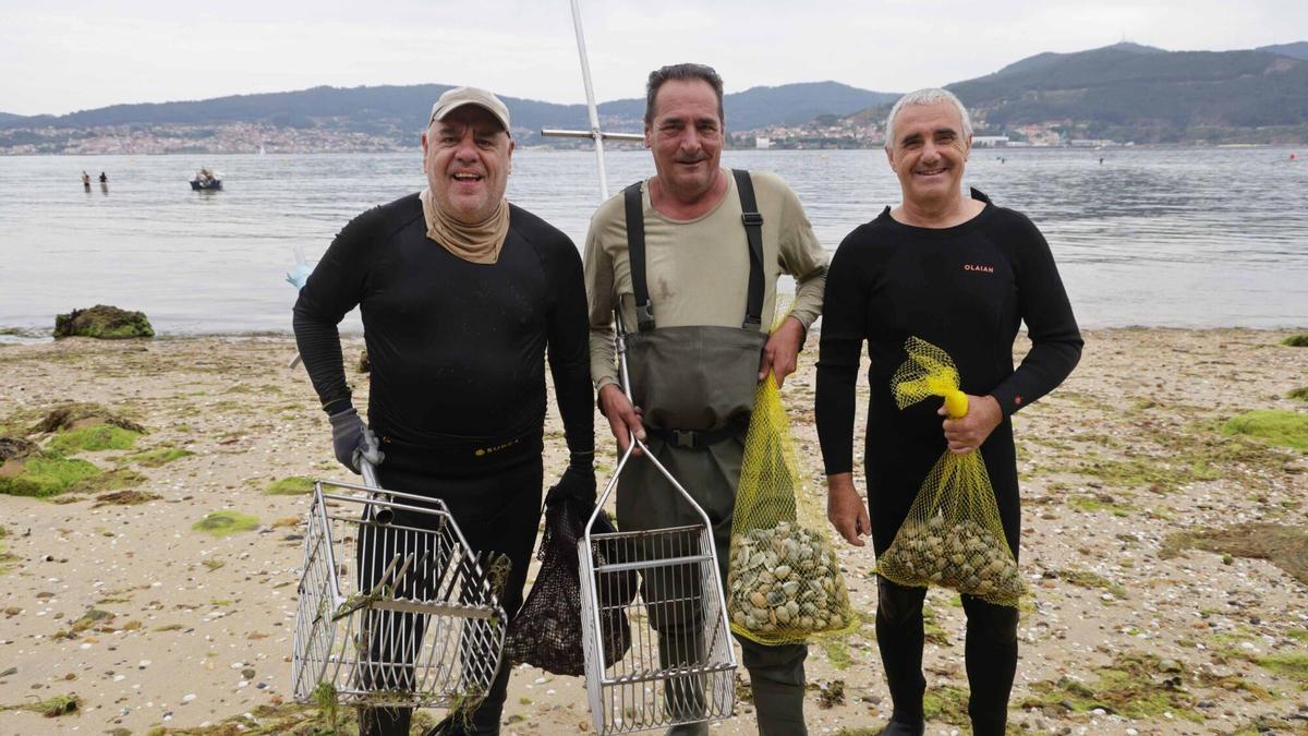 Mariscadores vigueses muestran la almeja babosa extraída este martes de O Areíño.