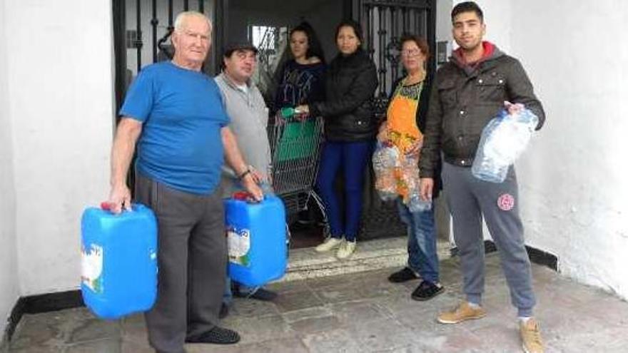 Integrantes de las cuatro familias, en el portal del edificio de titularidad municipal.