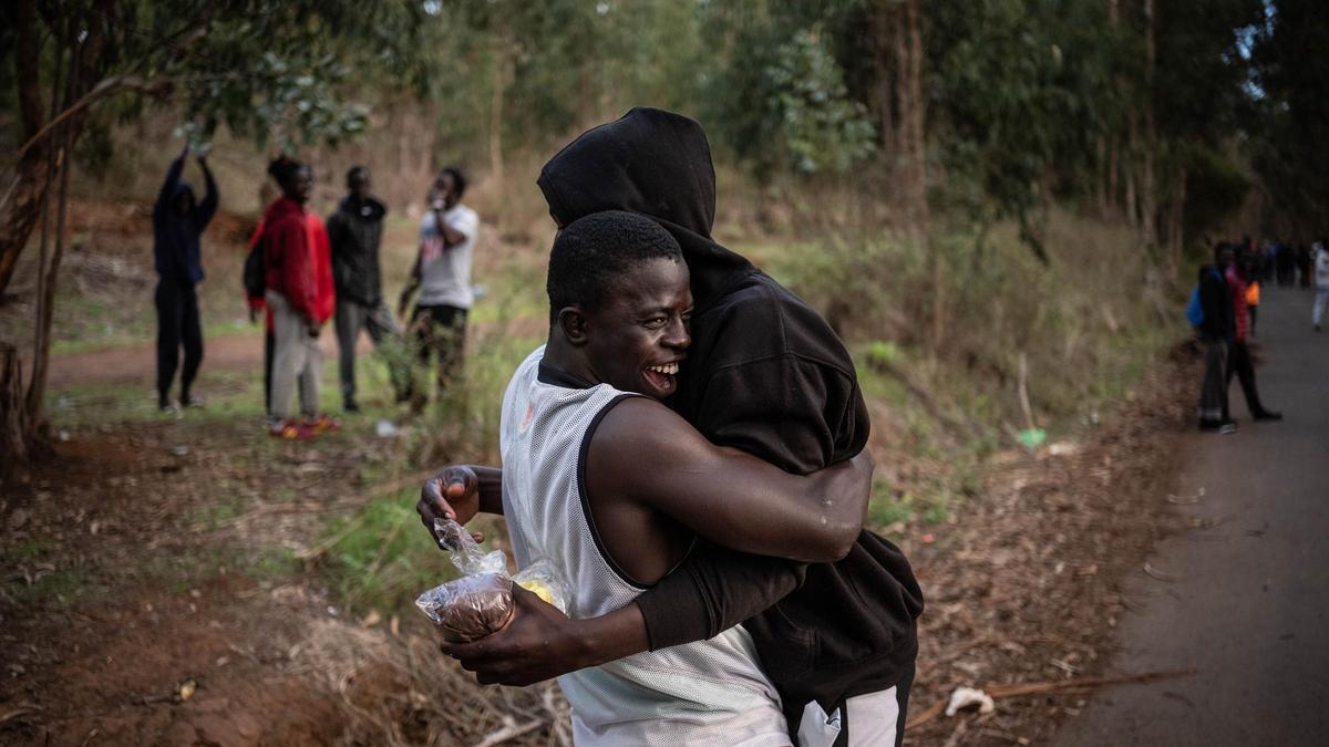 Dos migrantes se abrazan en el entorno del centro de acogida de Las Raíces.