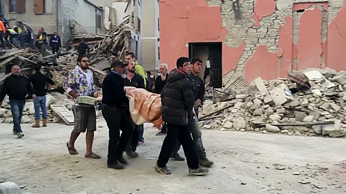 Traslado de una cadáver rescatado bajo los escombros.