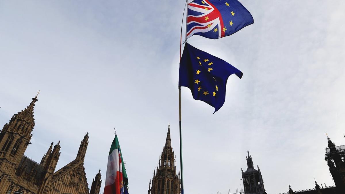 Un manifestante sostiene las bandera de Gran Bretaña y de la UE en una protesta ante el Parlamento británico, en Londres.