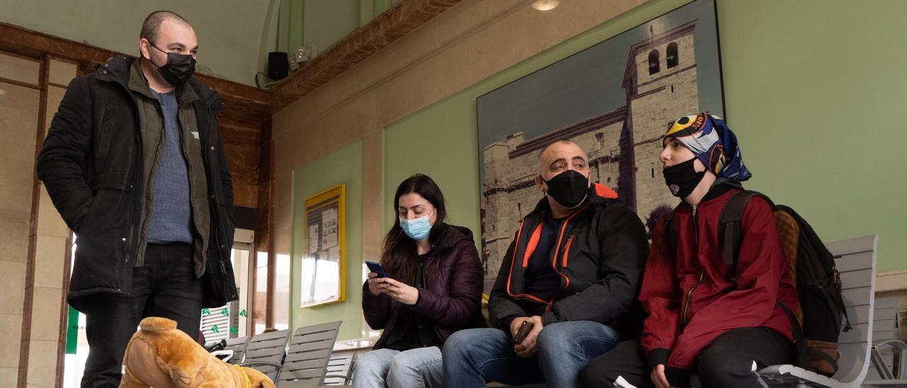 La familia espera en la sala de la estación a la llegada del tren que les llevará al sur