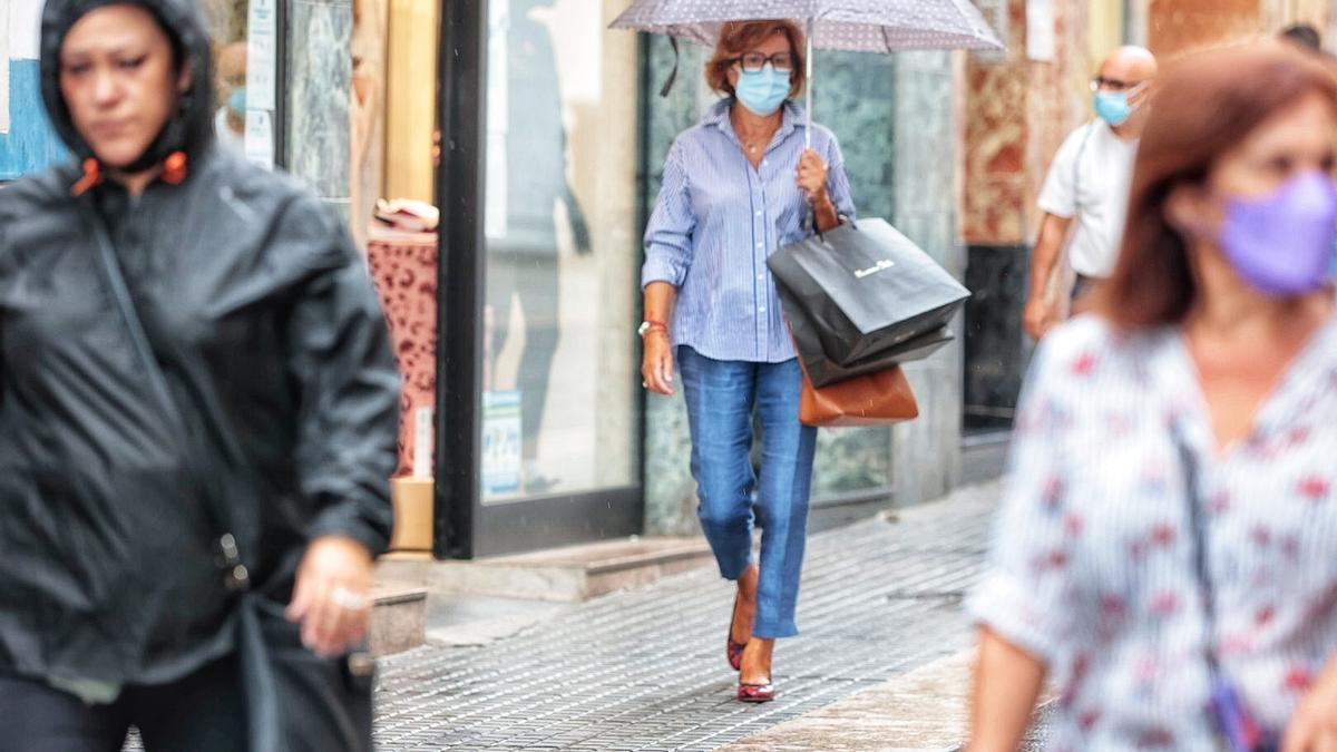 Varias personas con mascarilla caminan por Santa Cruz de Tenerife.