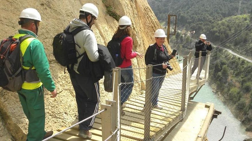 Un grupo de visitantes cruza uno de los tramos más populares del recorrido de más de ocho kilómetros que integran el espacio monumental del Caminito del Rey.