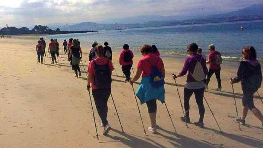 Un grupo de mujeres realizando una sesión de marcha nórdica en una playa de Cangas. // FdV