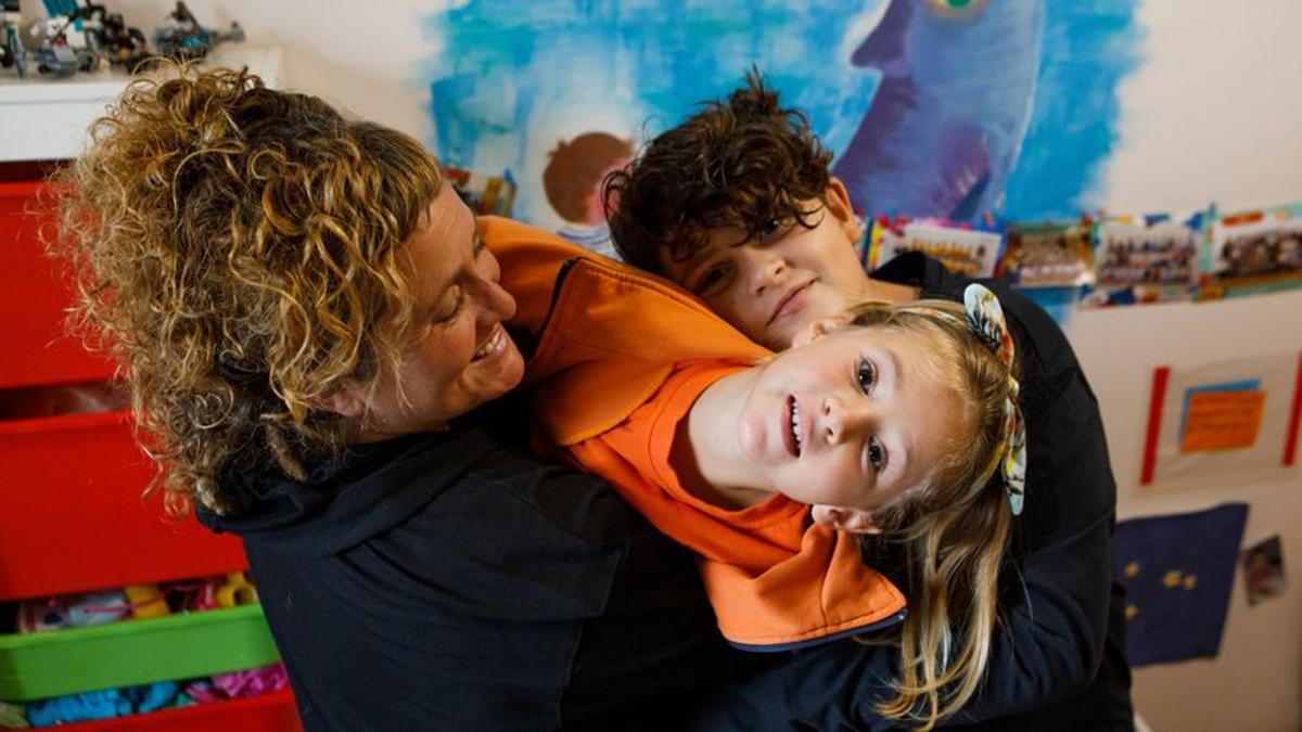 Martina y su hermano Lucas, con su madre Ana, en casa.